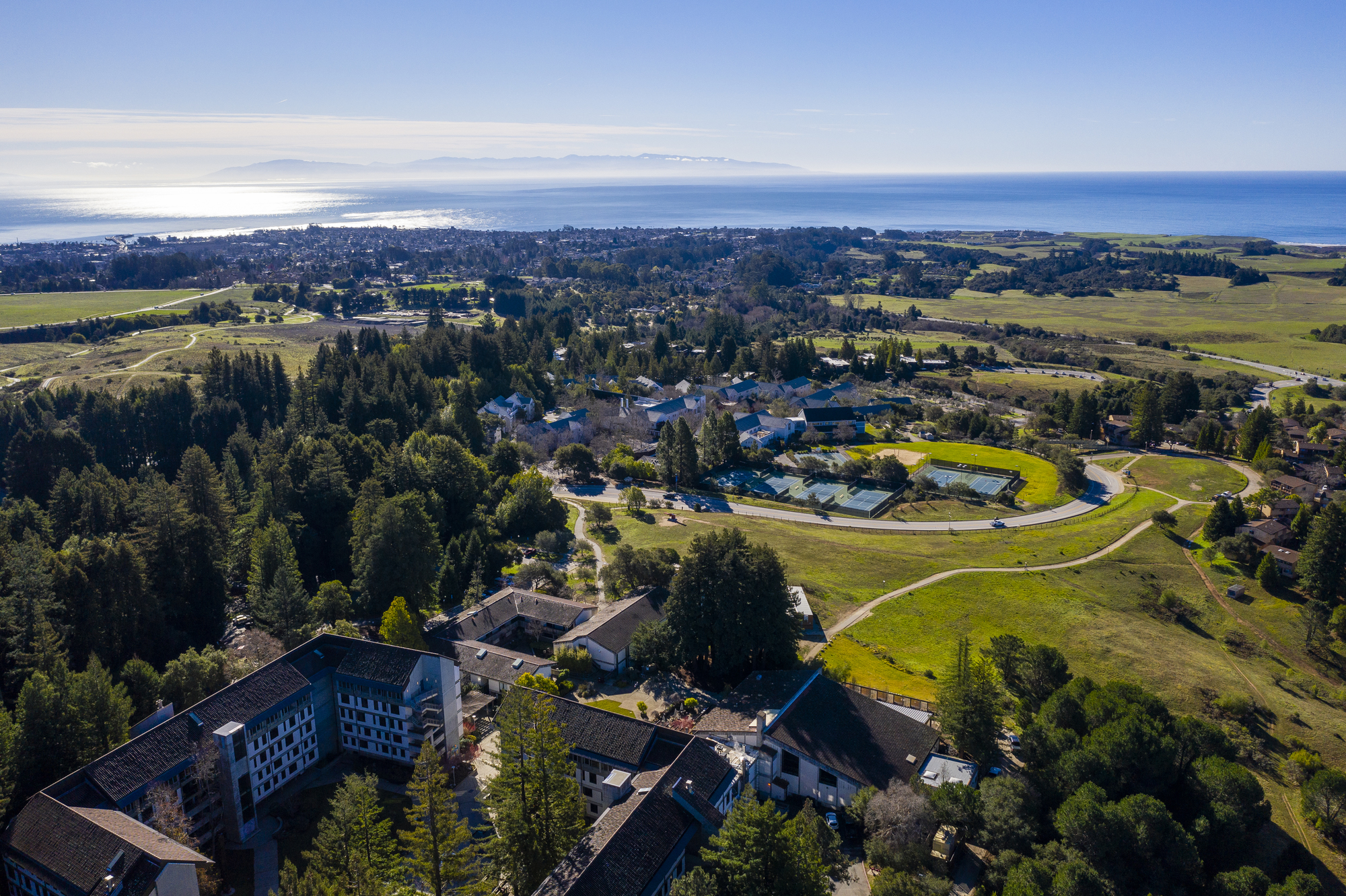 Aerial view looking down on campus with the Monterey Bay sparkling in the distance.