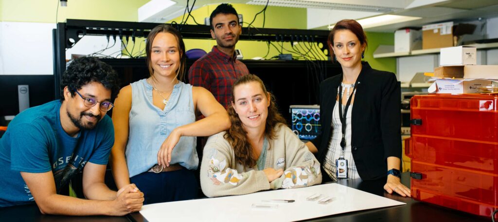 5 students smiling in the lab